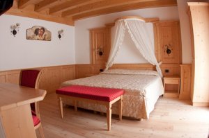 Foto di una delle camere, arredate con mobili in legno vecchio recuperato.